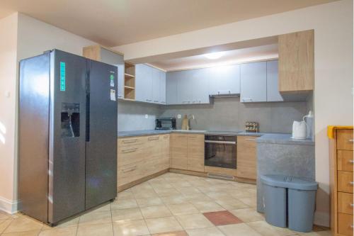 a kitchen with a stainless steel refrigerator and wooden cabinets at HELENOWO in Lutowiska