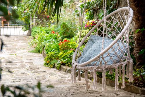a swing in a garden with flowers and plants at Apartments Roža in Roč
