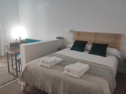 a bedroom with a bed with two towels on it at Apartamentos Atenea Jerte in Jerte