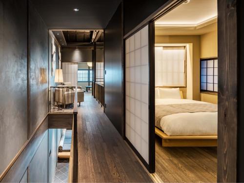 a hotel room with a bed and a hallway at Kanata Machiya House in Kanazawa