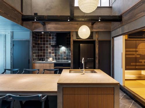 a kitchen with a large island with a sink at Kanata Machiya House in Kanazawa