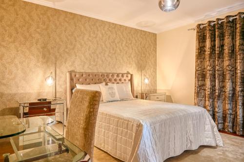 a bedroom with a bed and a glass table at Villa Mendonca, a Home in Madeira in Canhas