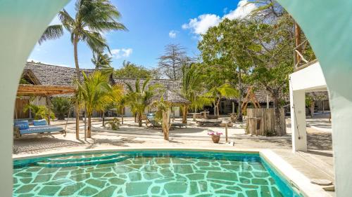 una piscina en un patio con palmeras en The Mida Creek Hotel en Watamu