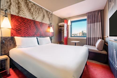 a hotel room with a large bed and a window at Ibis Marne la Vallée Noisy in Noisy-le-Grand