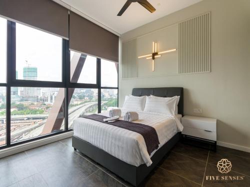 a bedroom with a large bed and large windows at Scarletz Suites Kuala Lumpur, Five Senses in Kuala Lumpur