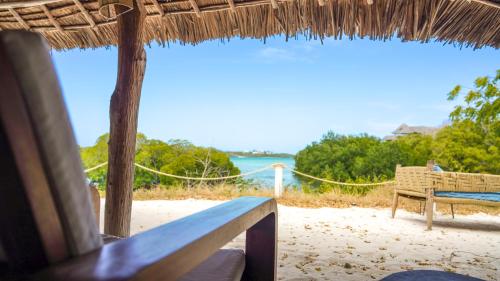 a bench on a beach with a view of the ocean at The Mida Creek Hotel in Watamu
