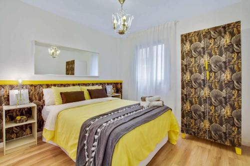 a bedroom with a large bed with a yellow blanket at MÁlaga Playa in Málaga