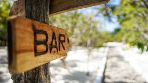 a wooden sign with the word bar on a wooden pole at The Mida Creek Hotel in Watamu