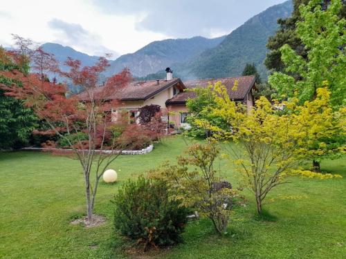 ein Haus inmitten eines Gartens mit Bäumen in der Unterkunft Relax in Pineta in Caldonazzo