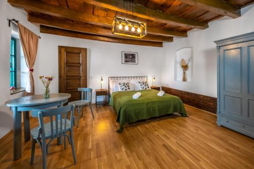 a bedroom with a bed and a table and chairs at Ferrata Vár Vendégház in Csesznek