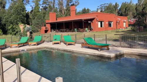 a group of chairs sitting next to a swimming pool at Quinta El Monte in Tandil