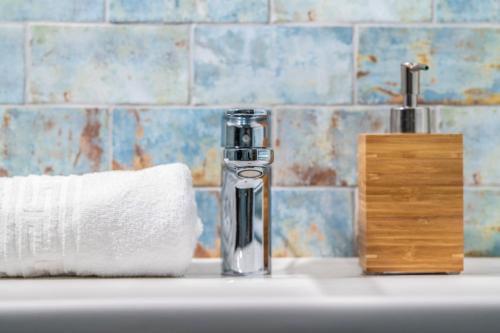 a bathroom sink with a soap dispenser and a roll of paper towels at Ferrata Vár Vendégház in Csesznek