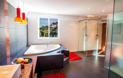 y baño con bañera, lavamanos y ducha. en Villa Fanny en Ribeira Brava
