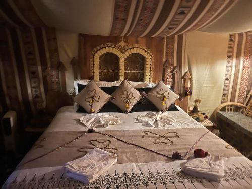 a bedroom with a large bed with a canopy at Tente et Restaurant ElBey in Douz