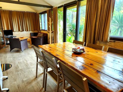 una gran mesa de madera en una habitación con sillas en House & Yard Sesil XL 90m to beach, en Ureki
