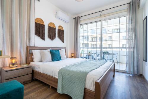 a bedroom with a bed and a large window at Araminta 2-Bedroom Apartment in Larnaca in Larnaka
