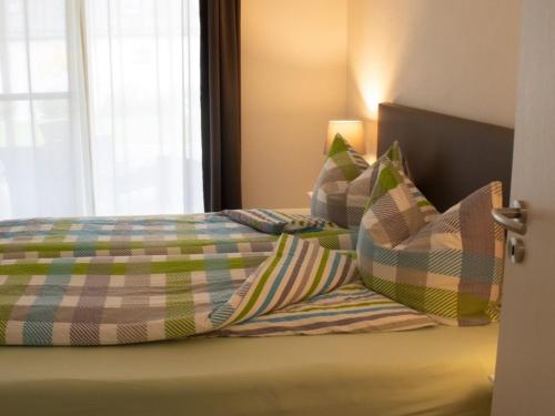 a bed with a comforter and pillows on it at Ferienwohnung Gute Zeit - Apartment 2 in Bleialf