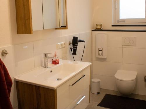 a bathroom with a sink and a toilet and a phone at Ferienwohnung Gute Zeit - Apartment 2 in Bleialf