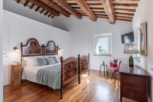 a bedroom with a large bed and a wooden floor at Villa Aga - Homelike Villas in Cingoli