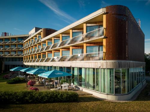 a building with tables and umbrellas in front of it at Georg Ots Spa Hotel in Kuressaare