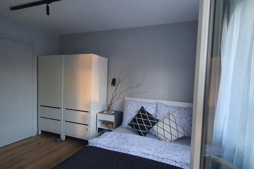 1 dormitorio con 1 cama y armario blanco en Piękny apartament w zielonej dzielnicy Wrocławia, en Wroclaw