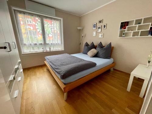 um quarto com uma cama grande e uma janela em Stadtwohnung am Oertelplatz em Munique