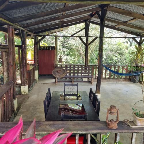 a patio with a wooden table and a bench at Princesa de la Luna Ecolodge in Fortuna