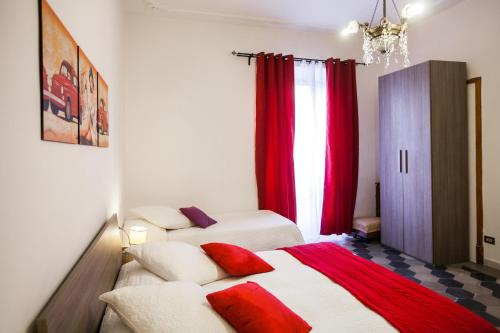 sypialnia z 2 łóżkami i czerwonymi zasłonami w obiekcie La Dolce Vita Roma w Rzymie