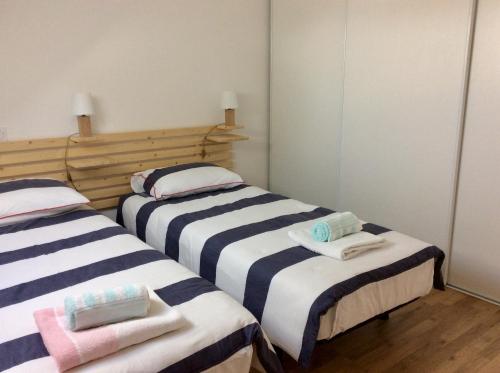 deux lits dans une chambre avec des serviettes dessus dans l'établissement LES AJONCS, à Arzon