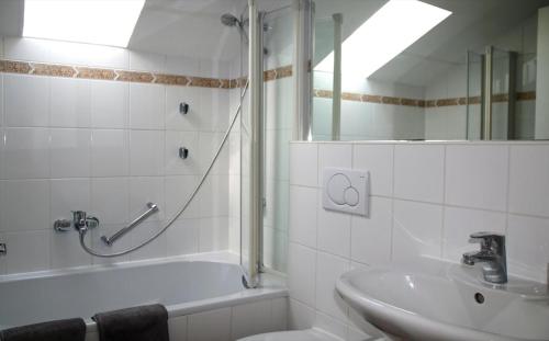 a bathroom with a sink and a bath tub and a mirror at Ferienwohnung Anette in Garmisch-Partenkirchen