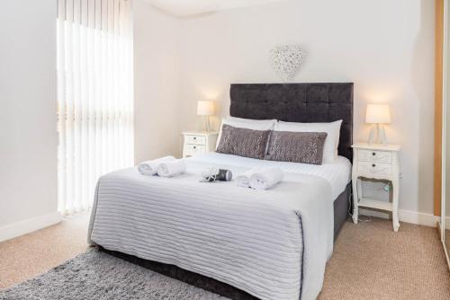 a bedroom with a large bed with towels on it at City Stay Apartments - Vizion in Milton Keynes