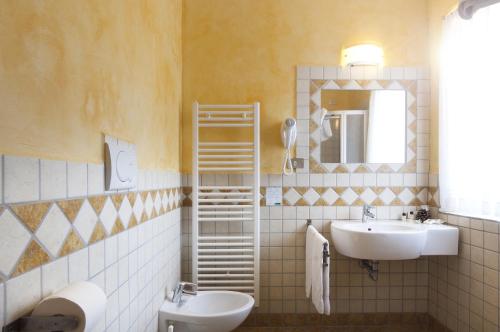 uma casa de banho com 2 lavatórios e um espelho em Grand Hotel Biancaneve em Folgaria