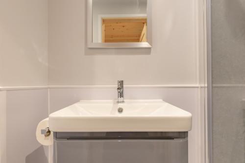 y baño con lavabo blanco y espejo. en Outdoor Inns - Star at Lidgate, en Newmarket