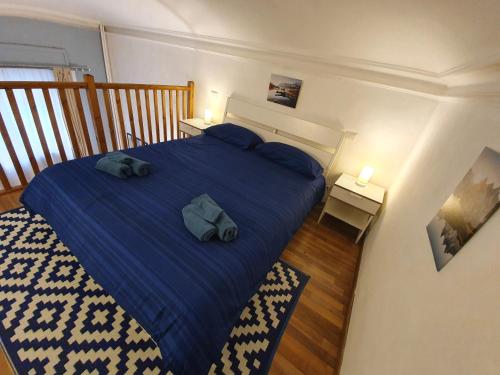 um quarto com uma cama azul com duas almofadas em Casa Marsili - Luxury Apartment em Turim