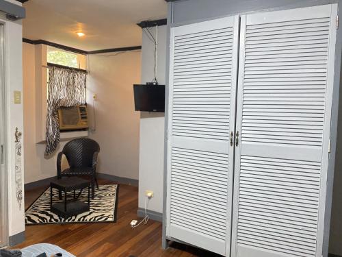 ein Zimmer mit einem großen weißen Schrank mit einem Stuhl in der Unterkunft La Vista Pansol Resort Complex by RedDoorz in Pansol