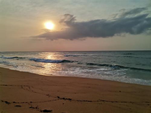a sunset on a beach with the ocean at Hello Holiday at 4 Boboyi Mangrove Beach Estate in Port Shepstone