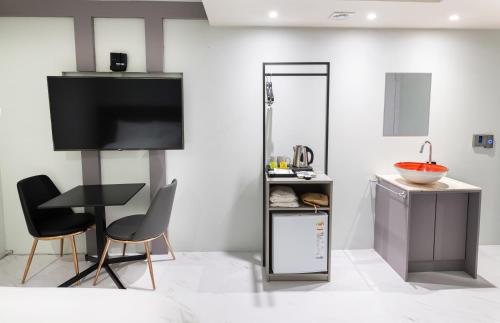 a kitchen with a tv and two chairs and a table at HOTEL LENITH Seomyeon in Busan