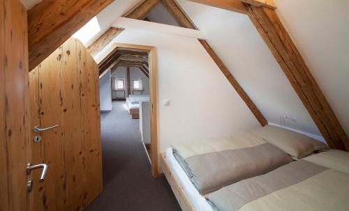 a attic room with a bed and a hallway at Ferienwohnungen Garhammer_ Kreuth_ in Kreuth