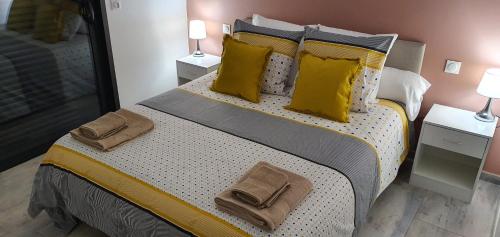 a bedroom with a large bed with yellow pillows at Villa le Moulin in Unzent