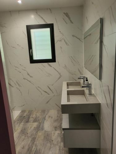 une salle de bain avec un lavabo et un miroir dans l'établissement Villa le Moulin, à Unzent