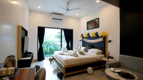 a bedroom with a bed and a tv and a table at Le Papillon By Bay Hotels in Lonavala