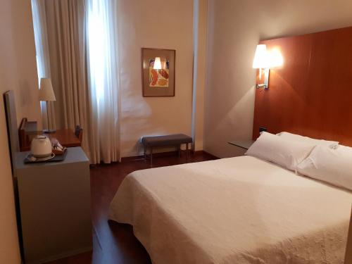 a hotel room with a bed and a table and lamp at Sant bonifaci petrer in Elda