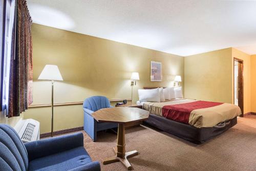 Habitación de hotel con cama, mesa y sillas en Jackson Inn, en Jackson