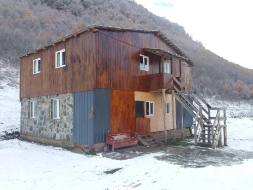 a building with a staircase in the snow at Vila Latphari in Ushguli in Ushguli