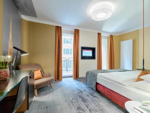 a hotel room with a bed and a desk at Hotel Capricorno in Vienna