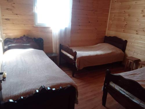 a room with two beds in a log cabin at Vila Latphari in Ushguli in Ushguli