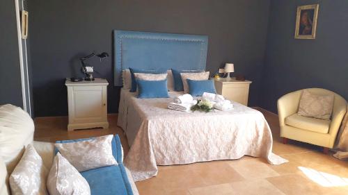 um quarto com uma cama com uma cabeceira azul e uma cadeira em LOS CLAVELES em Hornachuelos