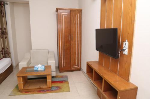 a living room with a tv and a coffee table at Platinum Hotel Ltd in Dhaka