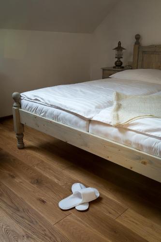 a bed with a pair of white shoes on the floor at U Námořníka-Restaurant a penzion in Hukvaldy