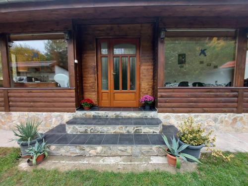 a house with a wooden door and some plants at Hámori Álom in Miskolc